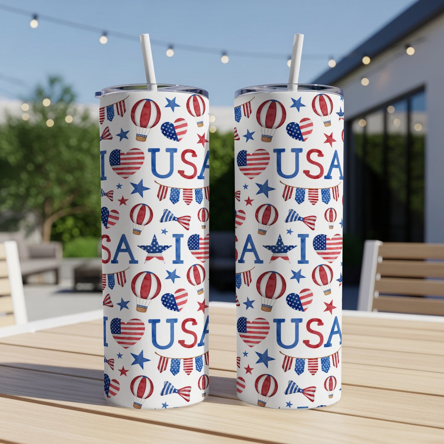 Two US flag-themed tumblers with patriotic patterns and straws on a table.