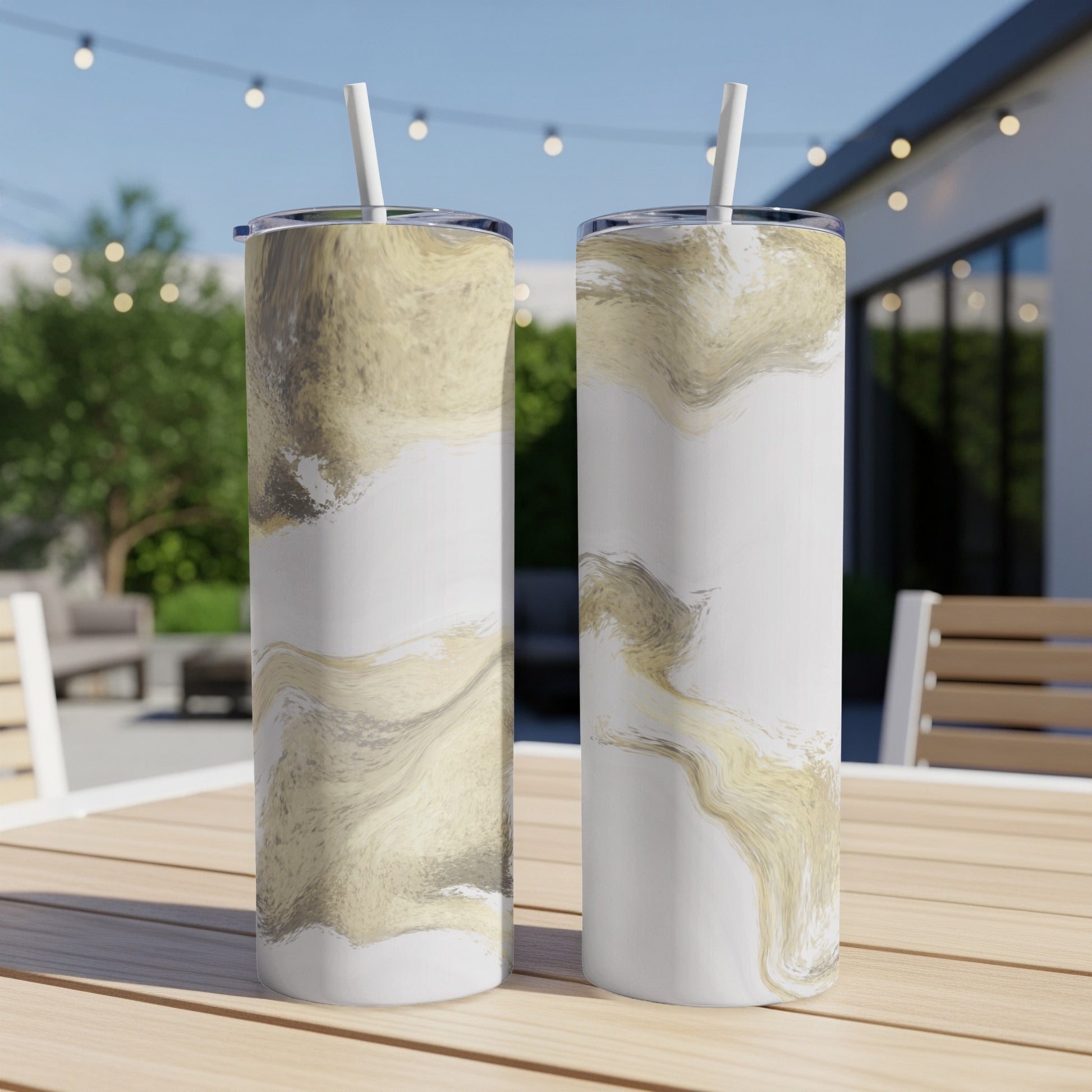 Two tall tumblers with a marbled gold and white design on a wooden table.