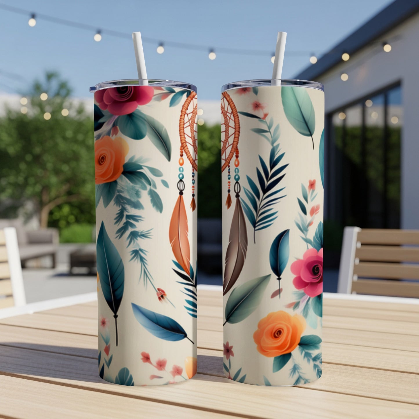 Two cream-colored tumblers with floral and feather designs on a wooden table.