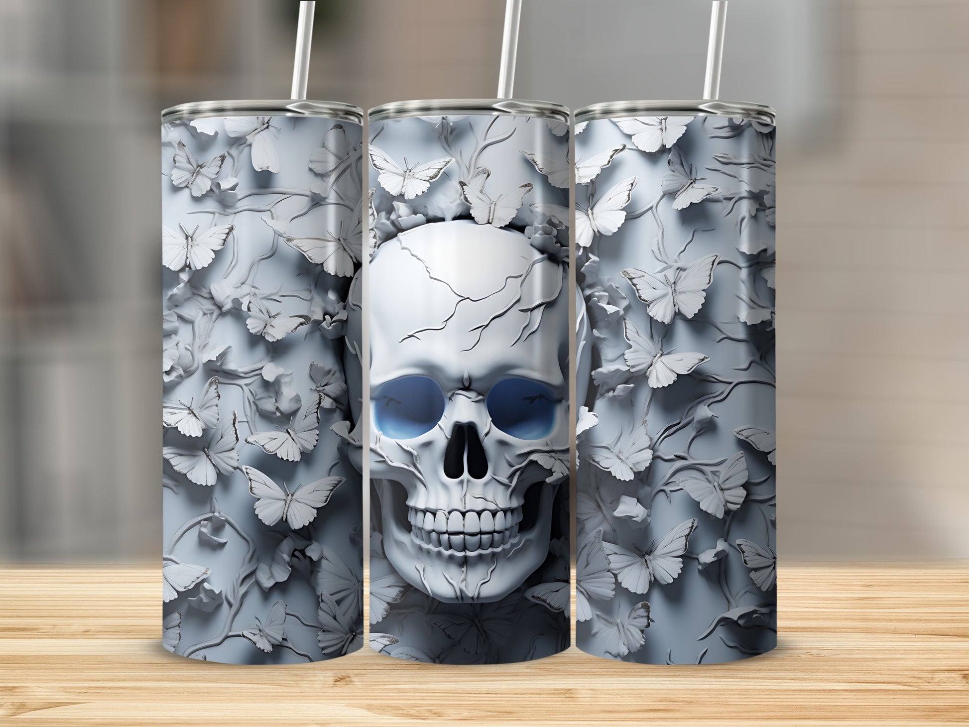 Three tall tumblers with a cracked skull and butterfly design.