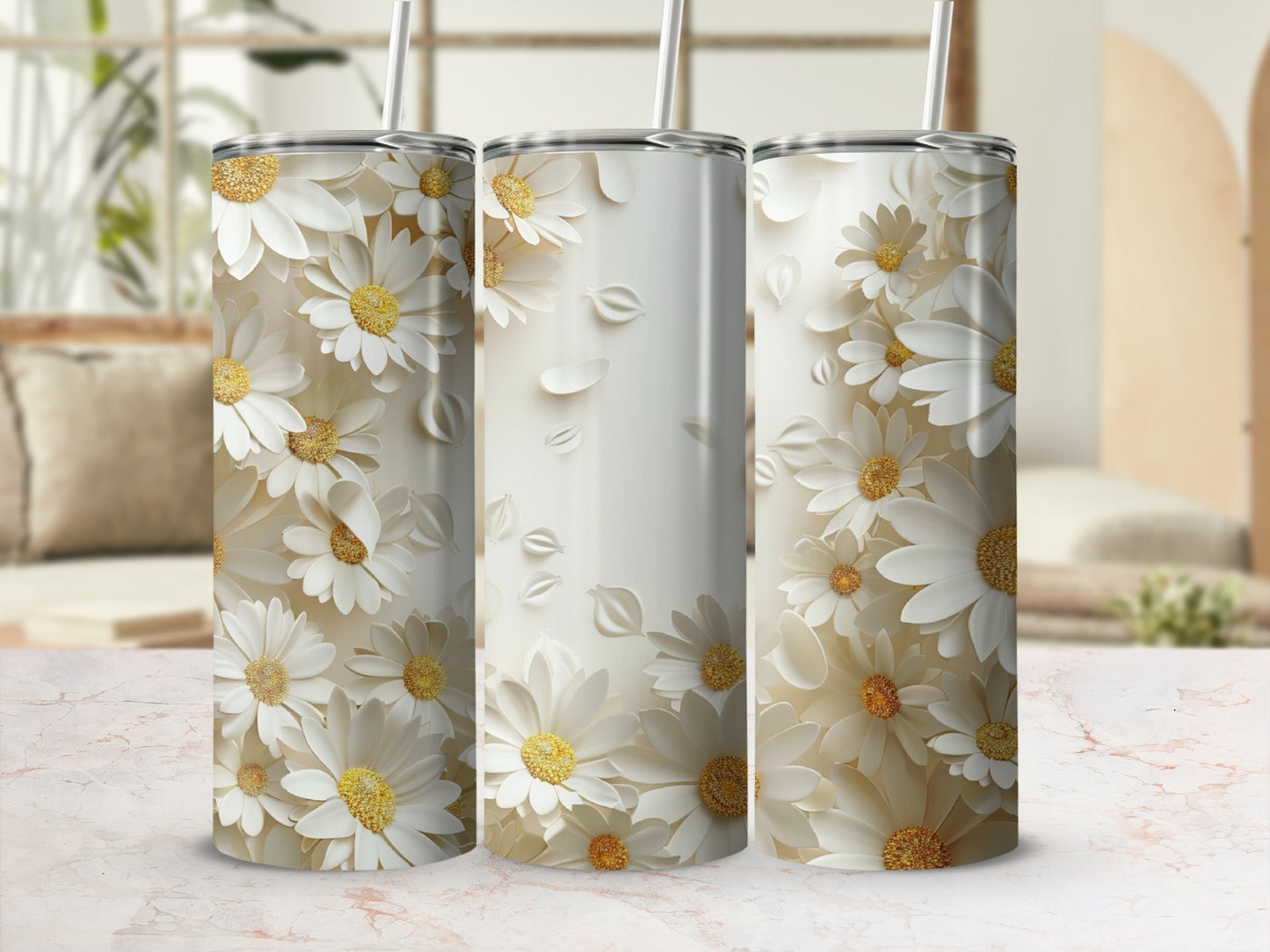 Three white daisy pattern tumblers with straws on a light marble surface.