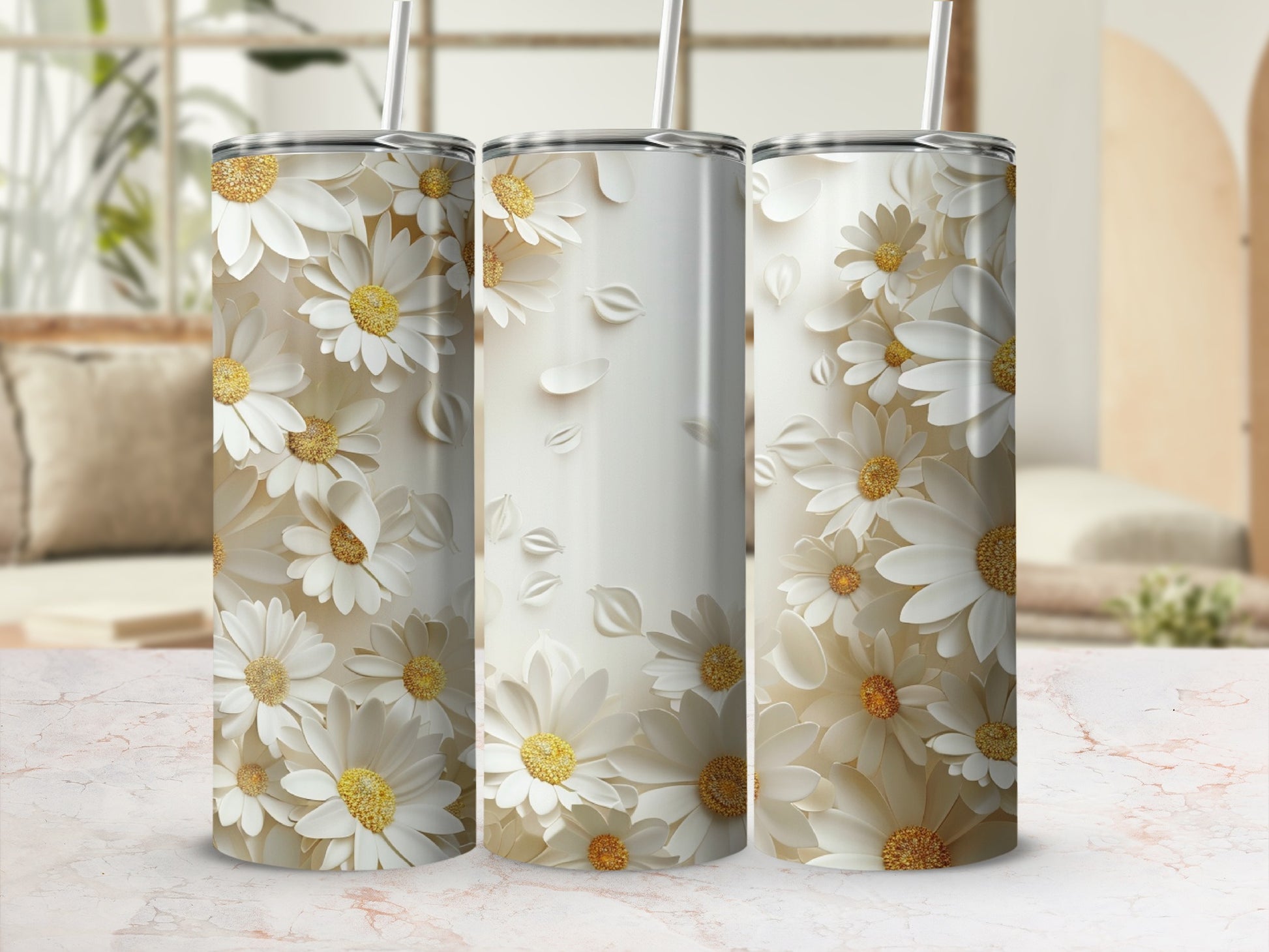 Three white daisy pattern tumblers with straws on a light marble surface.