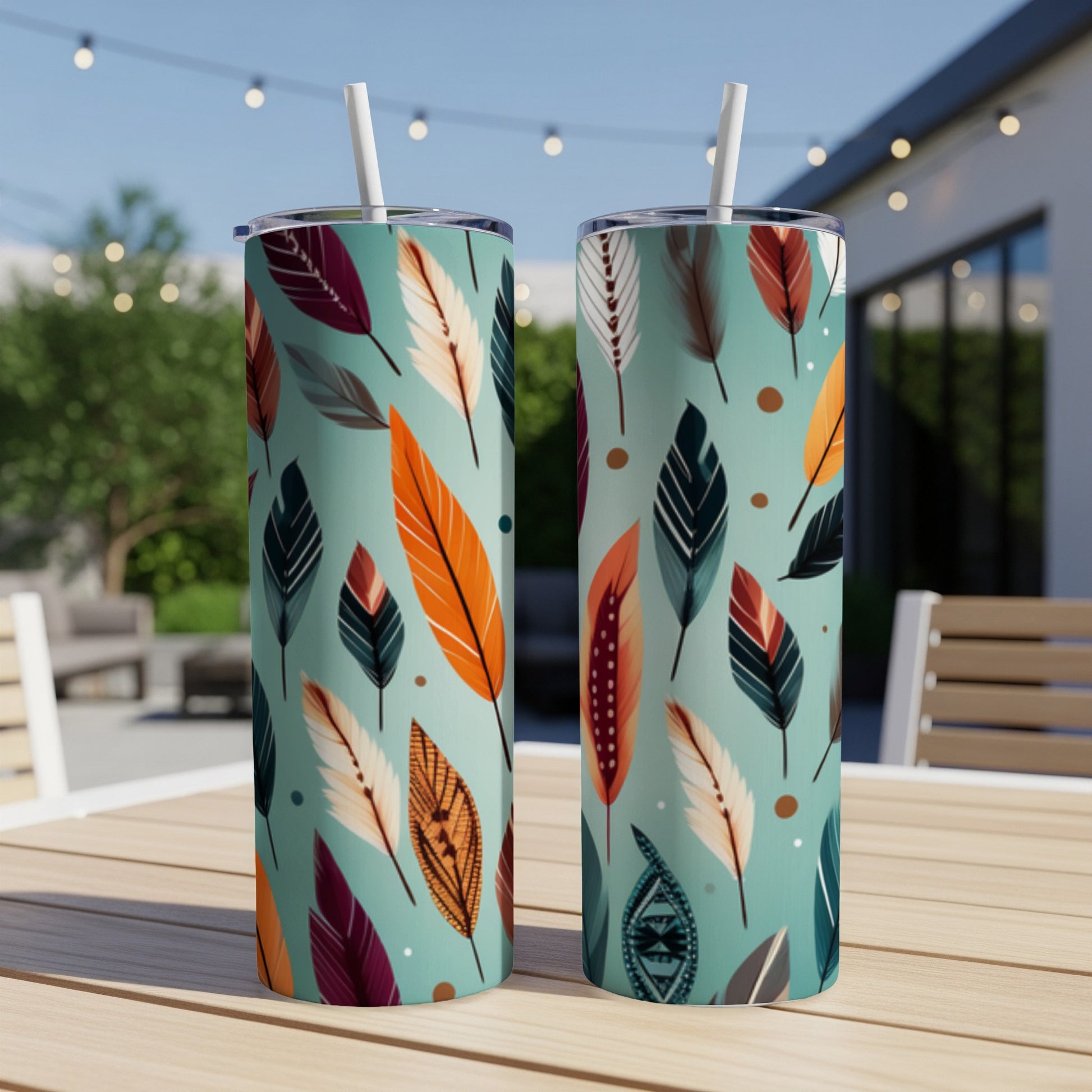 Two teal tumblers with a repeating pattern of colorful feathers.