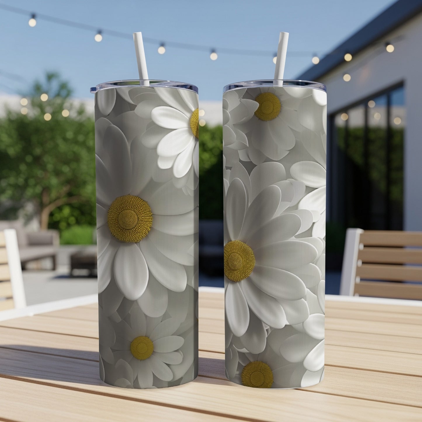 Two tall tumblers with white daisy floral pattern on a table.