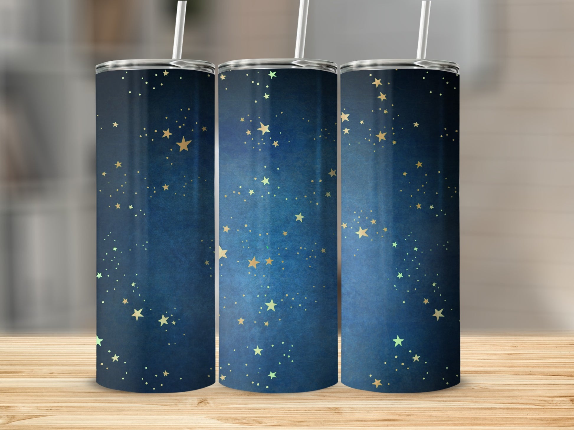 Three tumblers with a dark blue starry night print and straws.