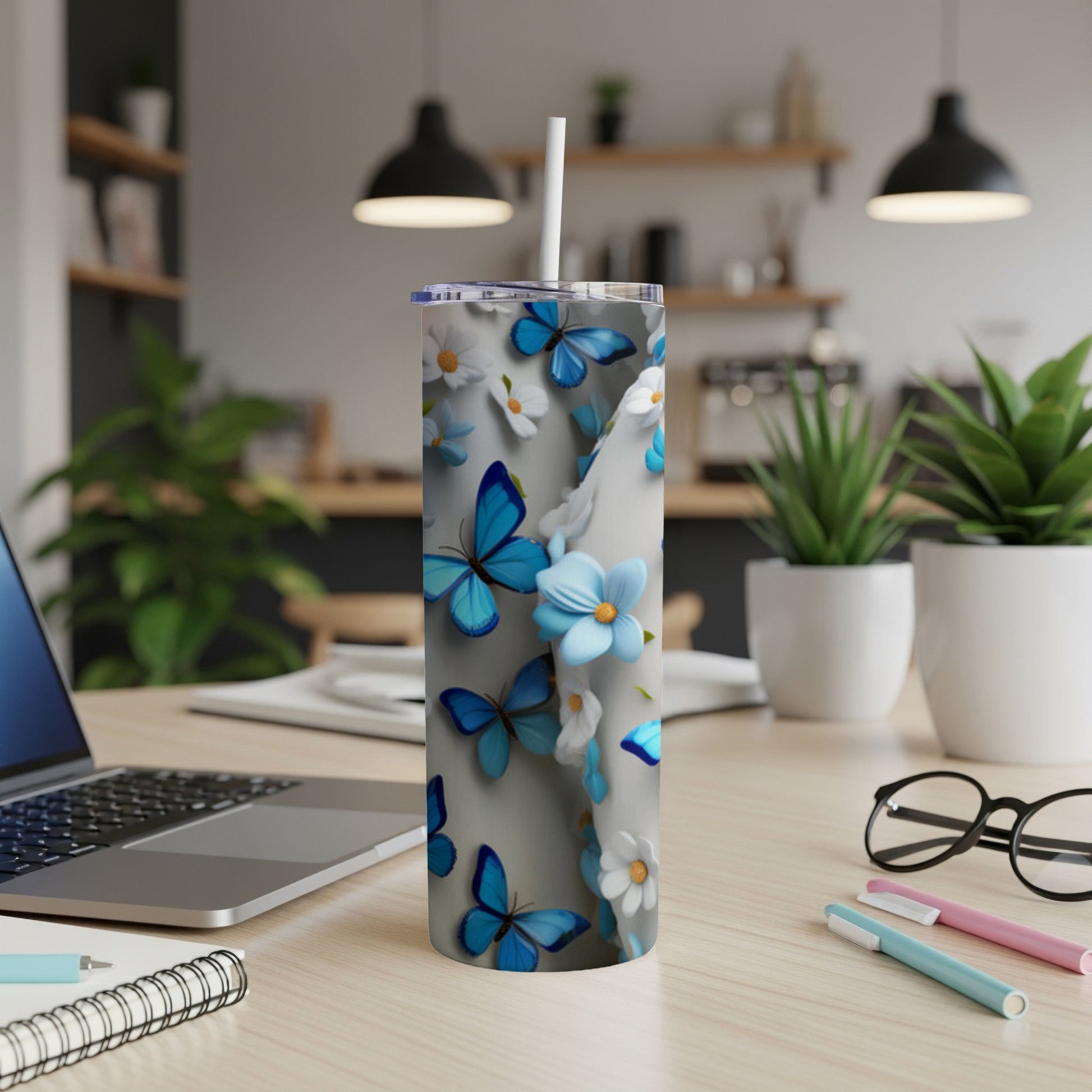 Blue butterflies and white flowers on a white tumbler with a straw.