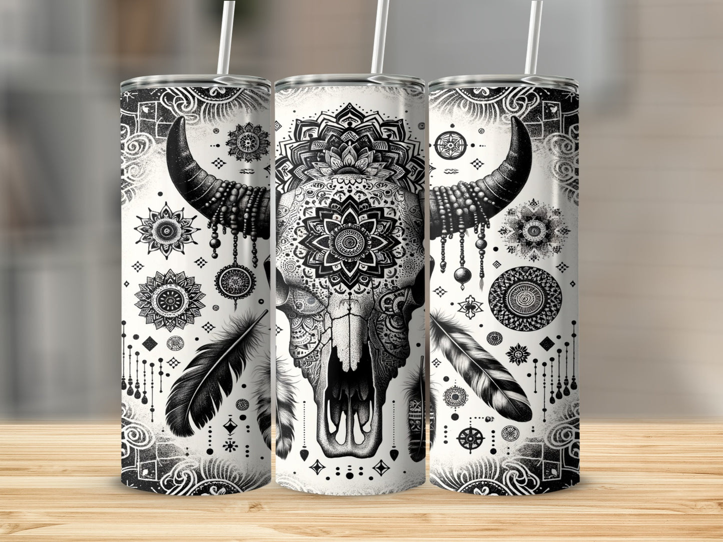 Three tumblers with black and white skull, feather, and mandala designs.