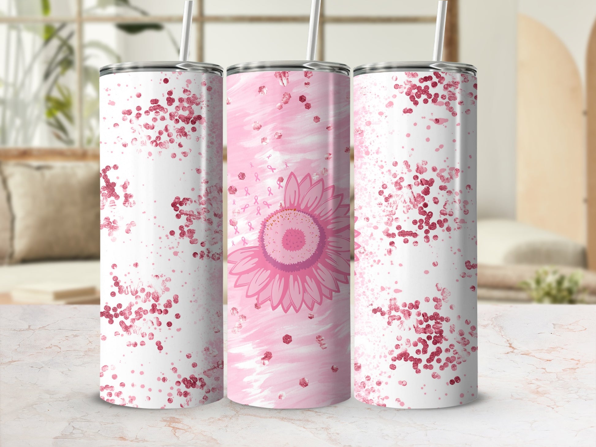 Pink glitter and sunflower design on three tumblers with straws.