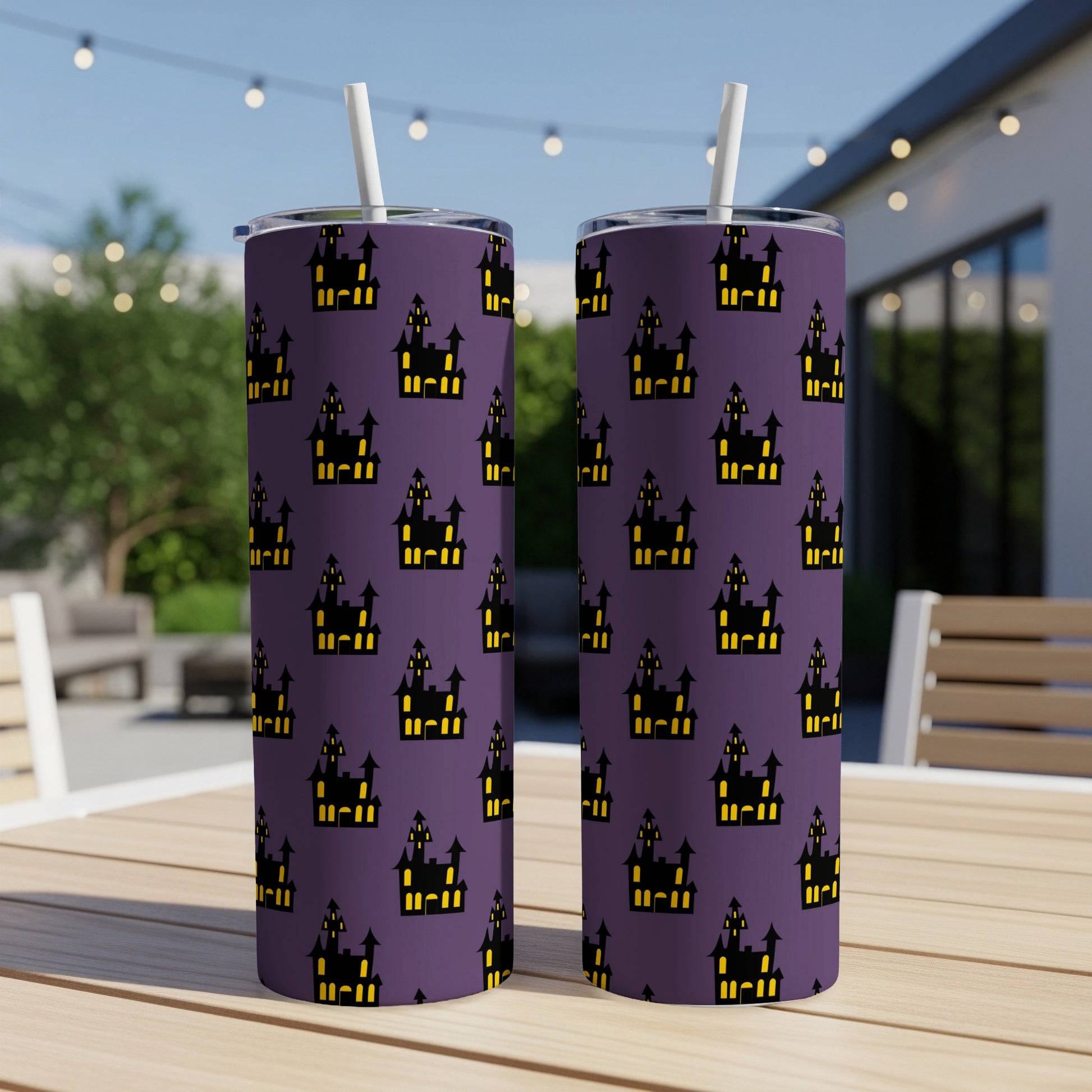 Two purple tumblers with a repeating black and yellow haunted house pattern.