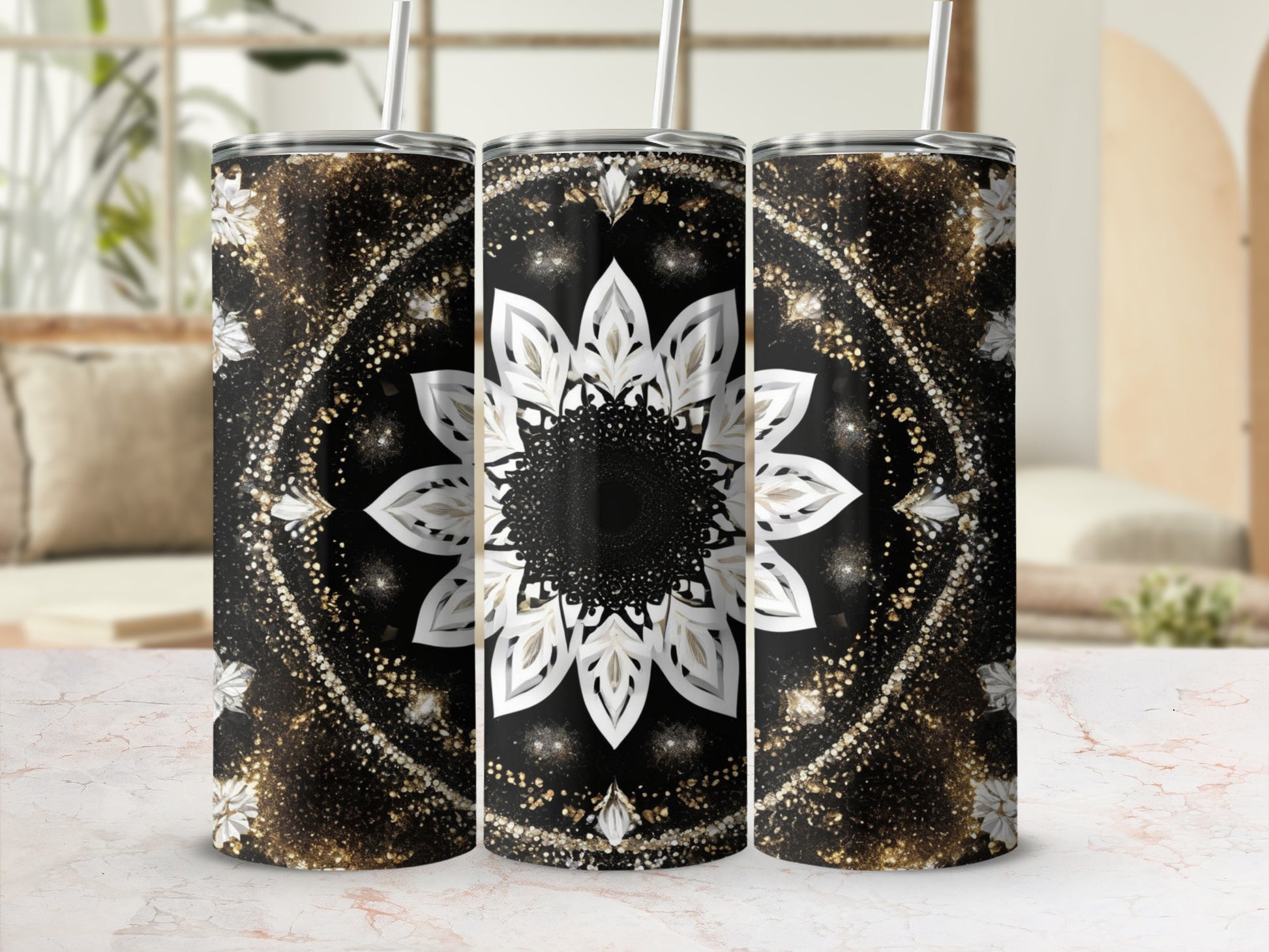Three tumblers with a black and gold mandala pattern on a marble surface.