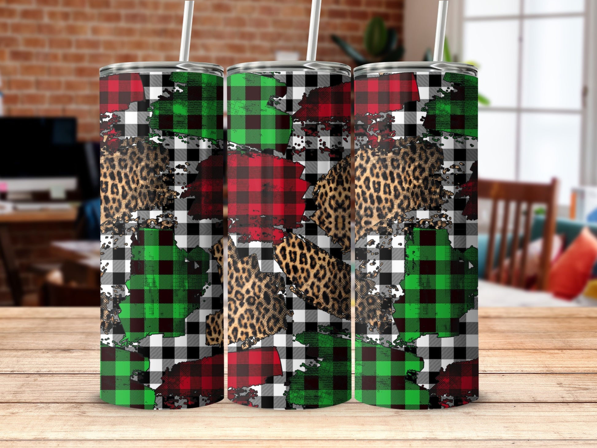 Three tumblers with plaid and leopard print designs on a wooden surface.