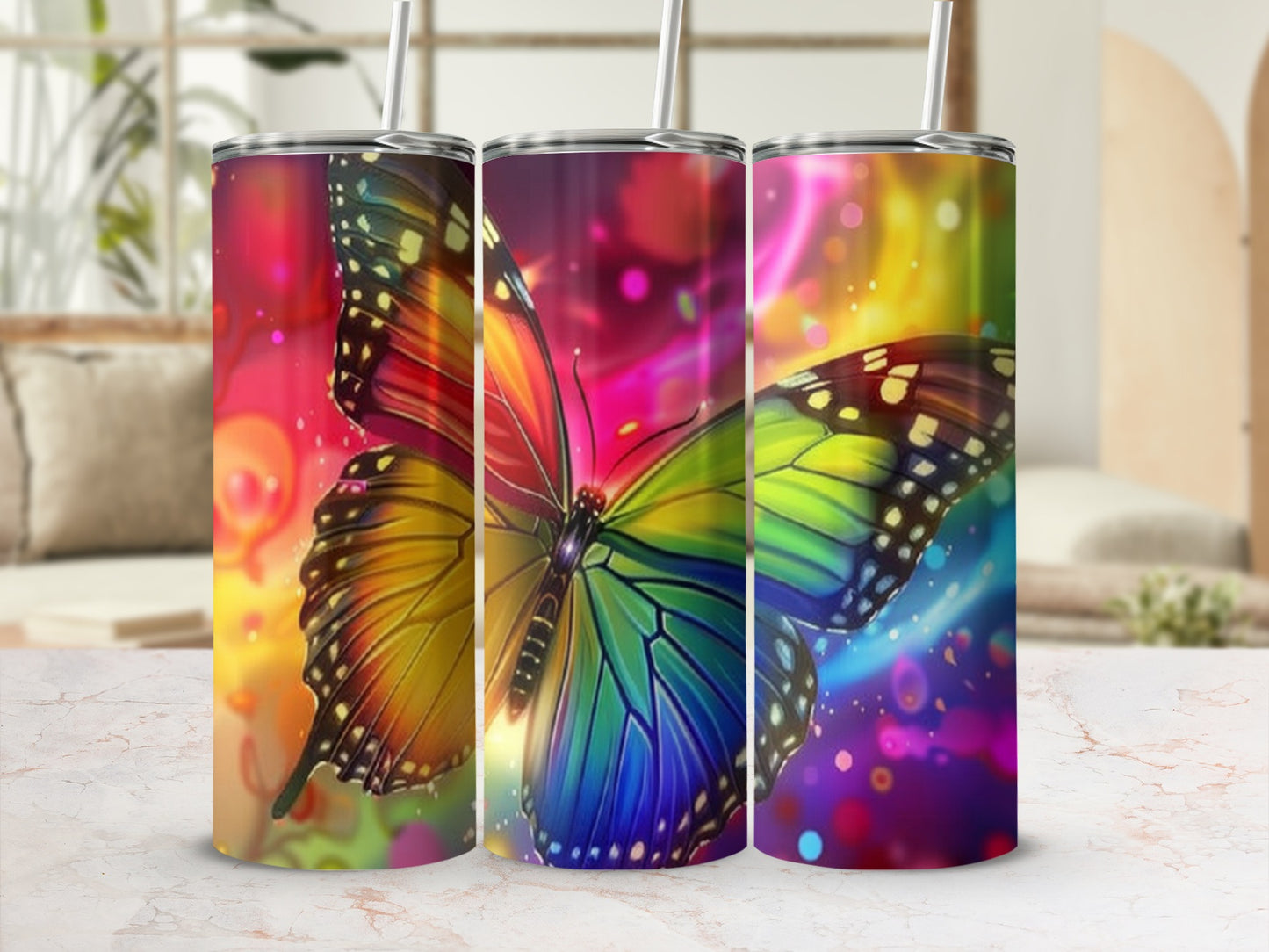 Three tumblers with colorful butterfly designs and bokeh light backgrounds.