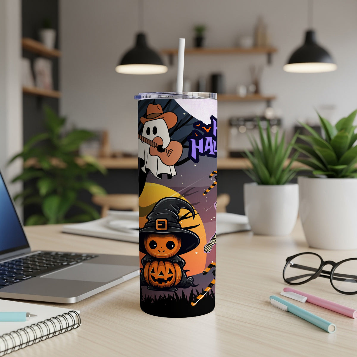 Halloween tumbler with pumpkin and ghost design, sitting on a desk.