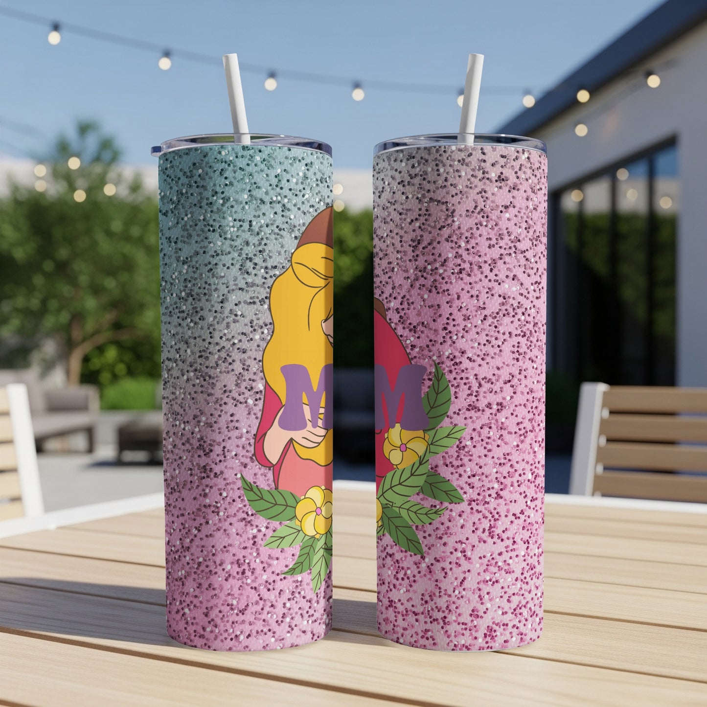 Two pink and blue glitter tumblers with a floral "Mom" design on a wooden table.