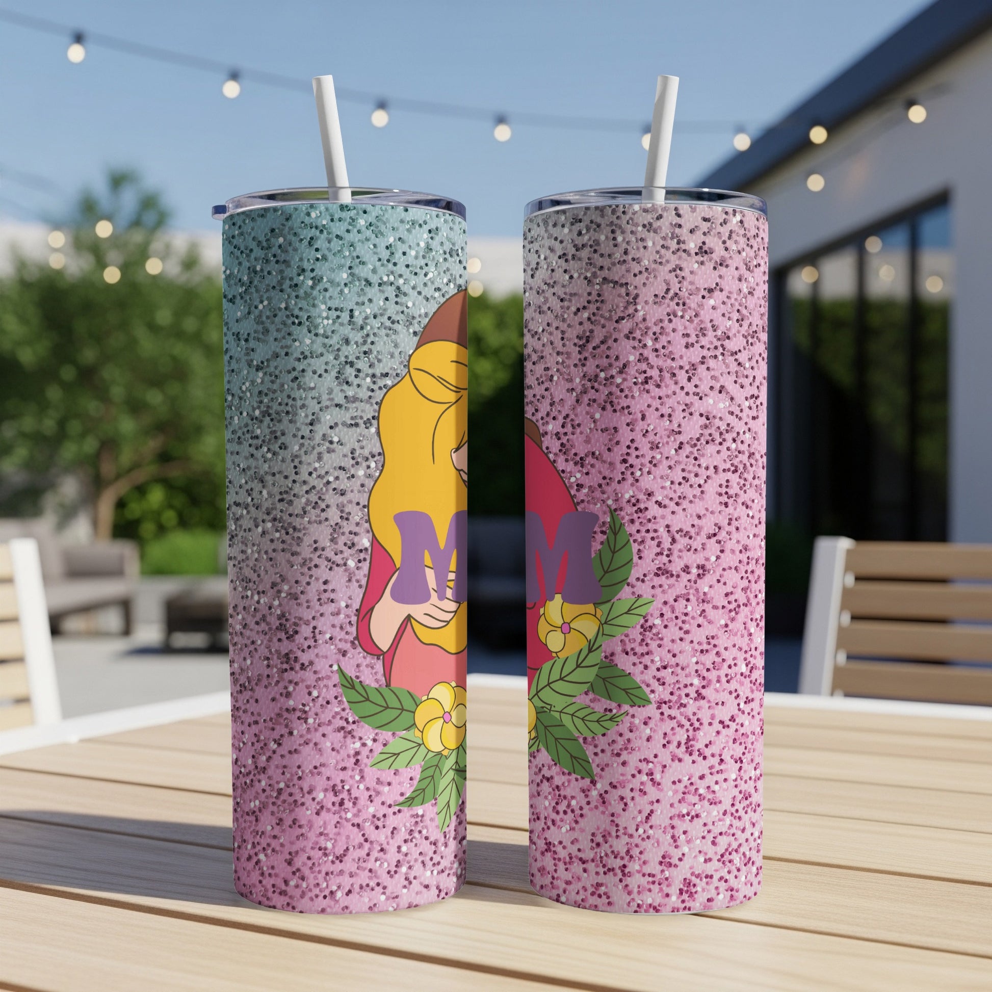 Two pink and blue glitter tumblers with a floral "Mom" design on a wooden table.