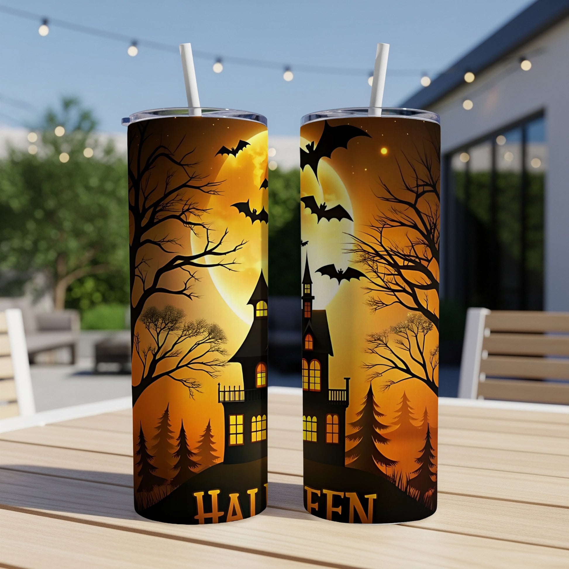 Two tumblers with Halloween design, featuring haunted houses, bats, and a full moon.
