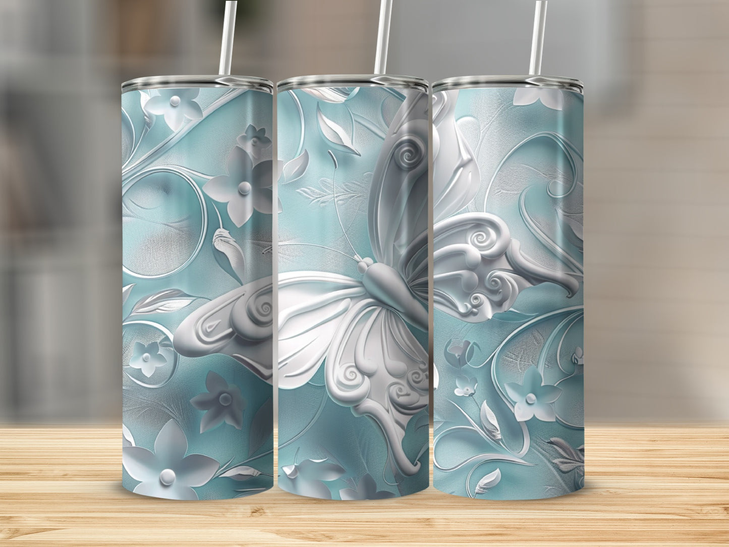 Three light blue tumblers with intricate white butterfly and floral embossed designs.
