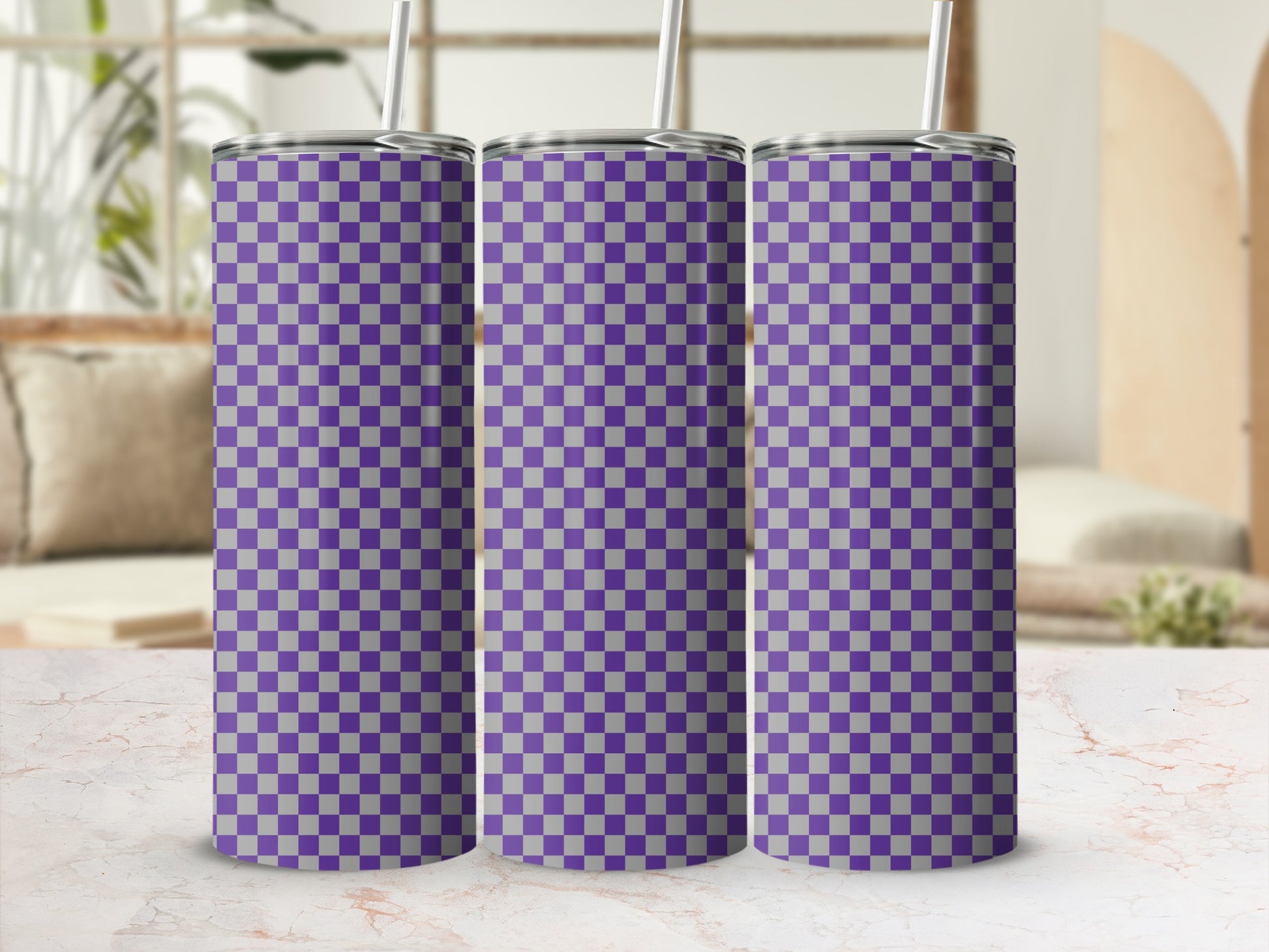 Three purple and gray checkered tumblers with straws on a marble surface.
