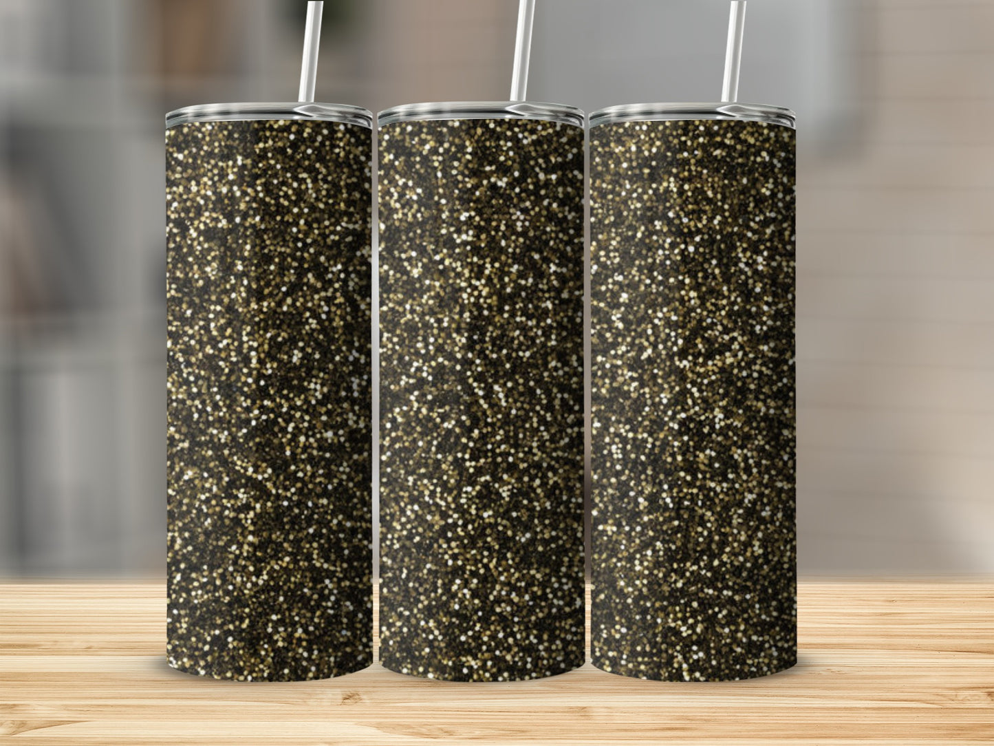 Three tumblers with gold and black glitter pattern stand on a wooden surface.