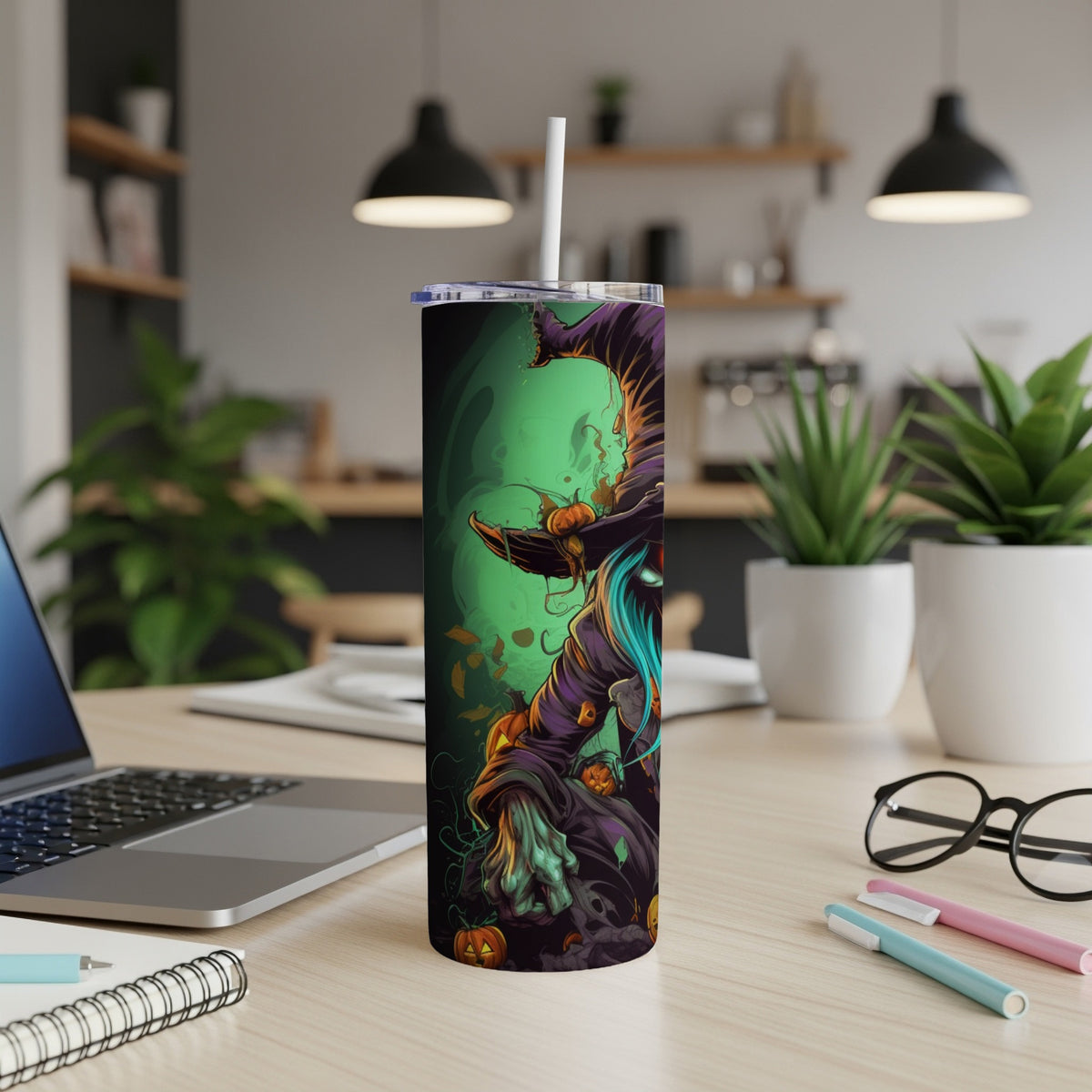 Halloween tumbler with witch and pumpkins design on desk.