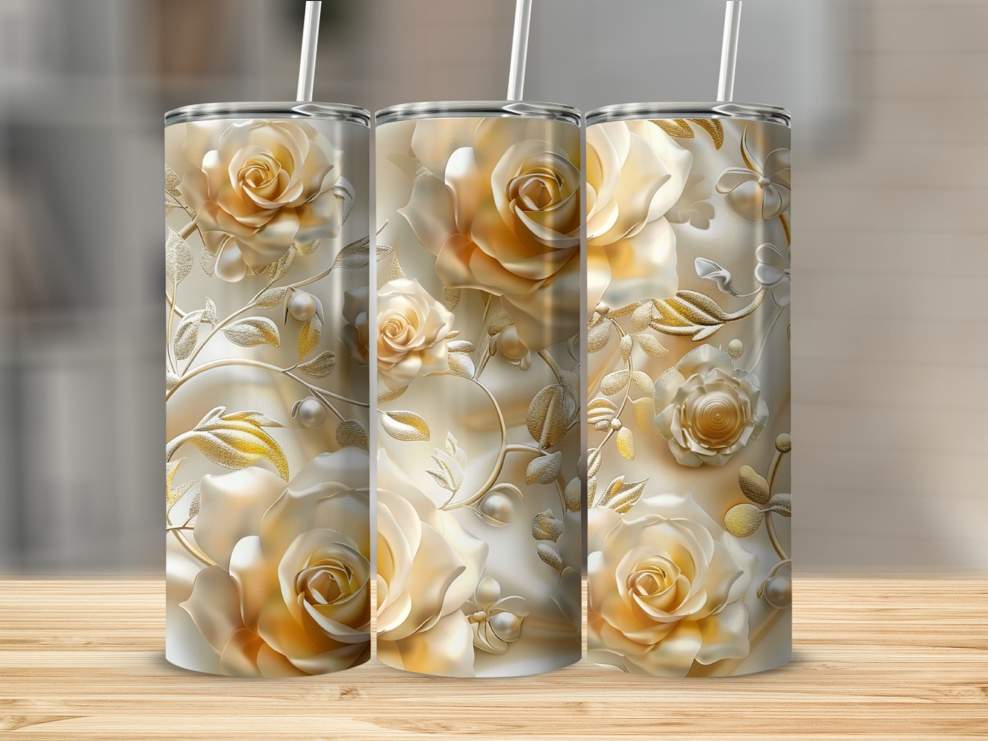 Three tumblers with ornate floral designs of golden roses and leaves.