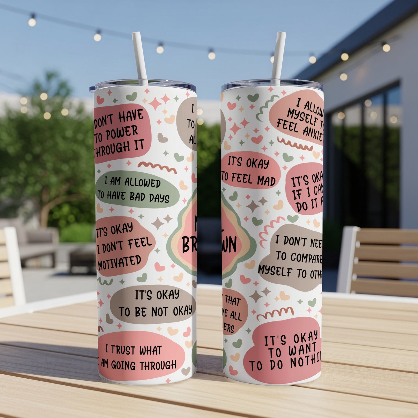 Tumbler with motivational phrases and heart designs on a table.