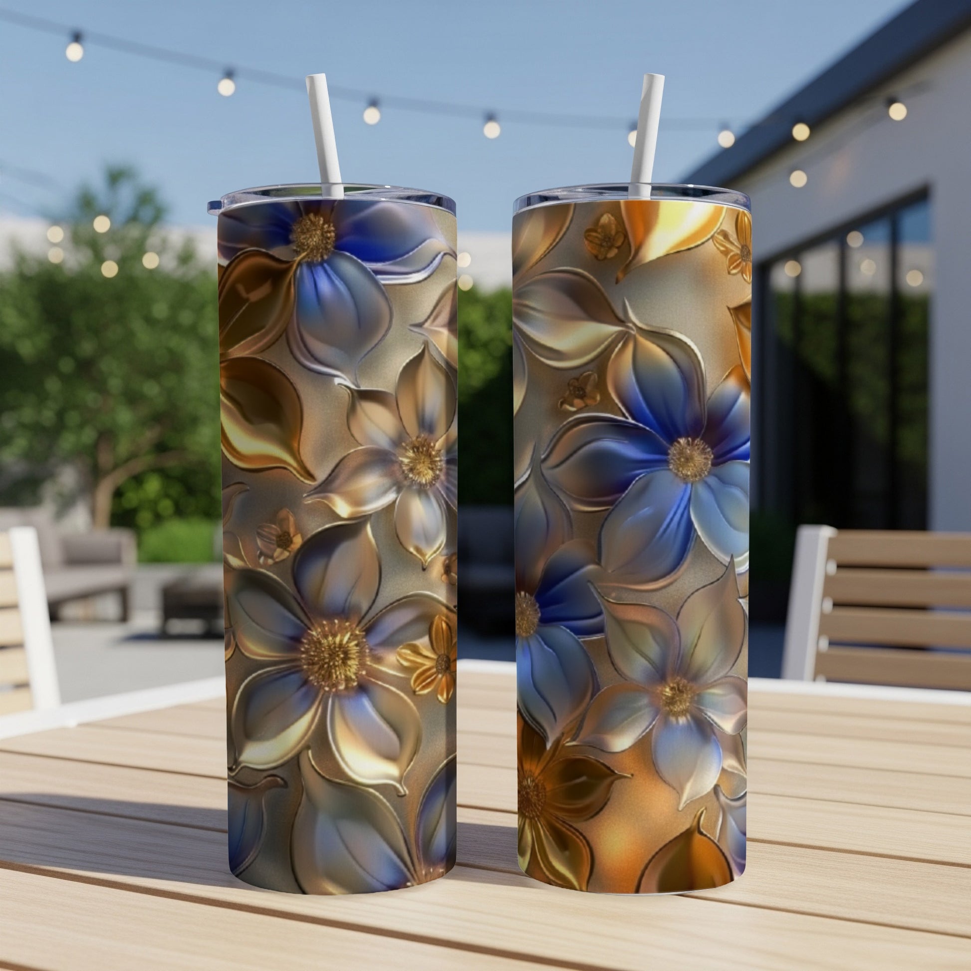 Two tall tumblers with metallic floral designs on a table.