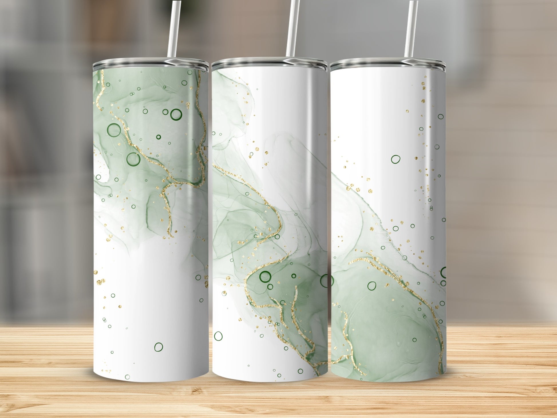 Three tall tumblers with green and gold abstract fluid art and straws.