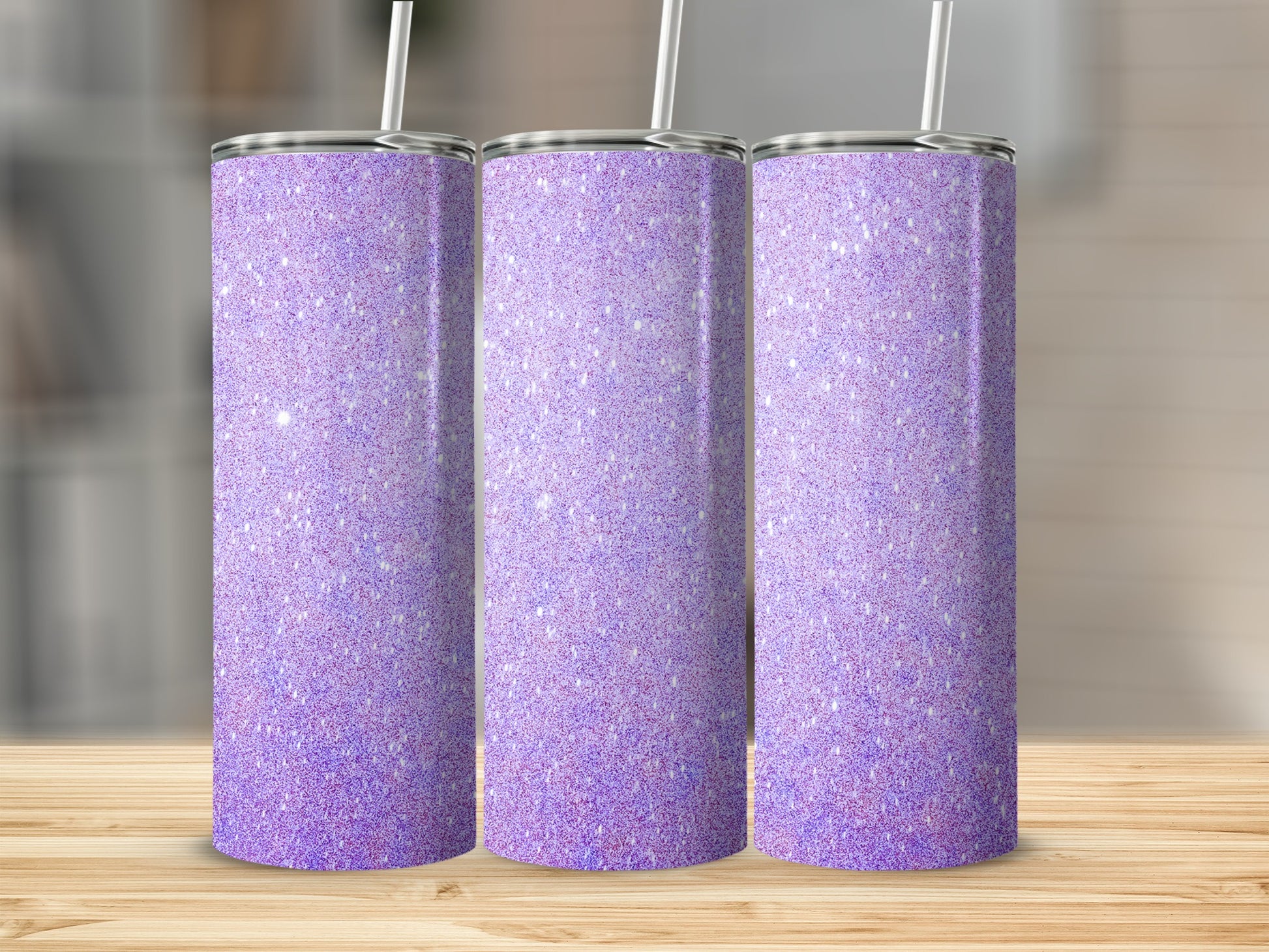 Three glittery purple tumblers with straws on a wooden surface.