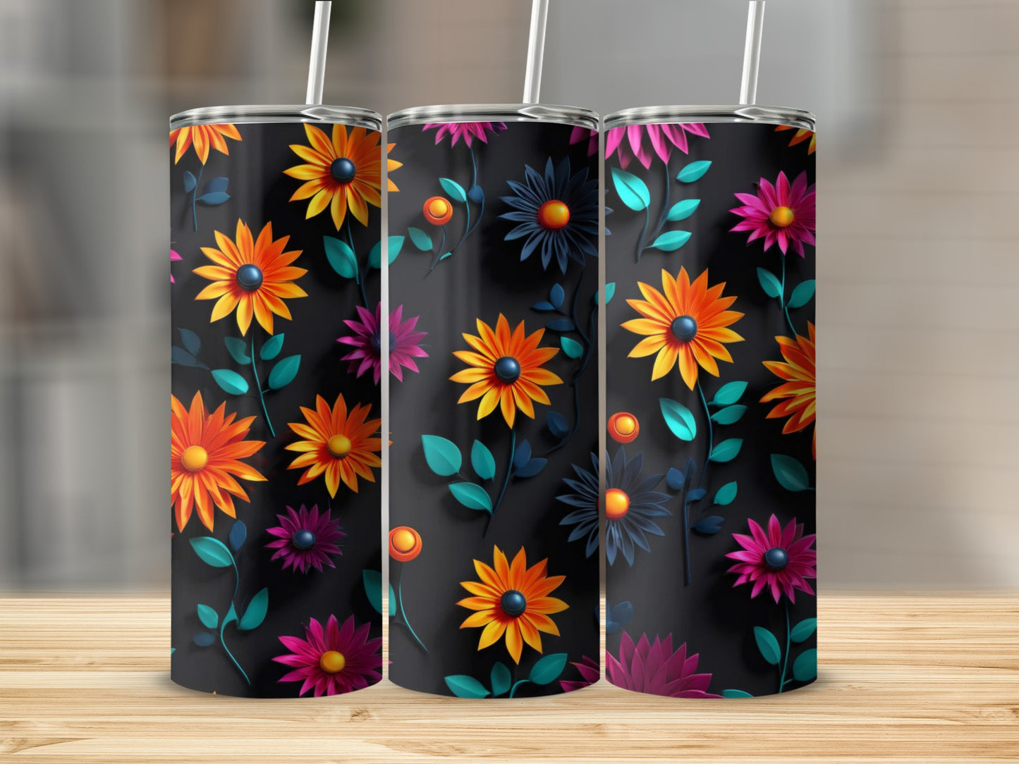 Three dark tumblers with vibrant floral patterns displayed on a wooden surface.