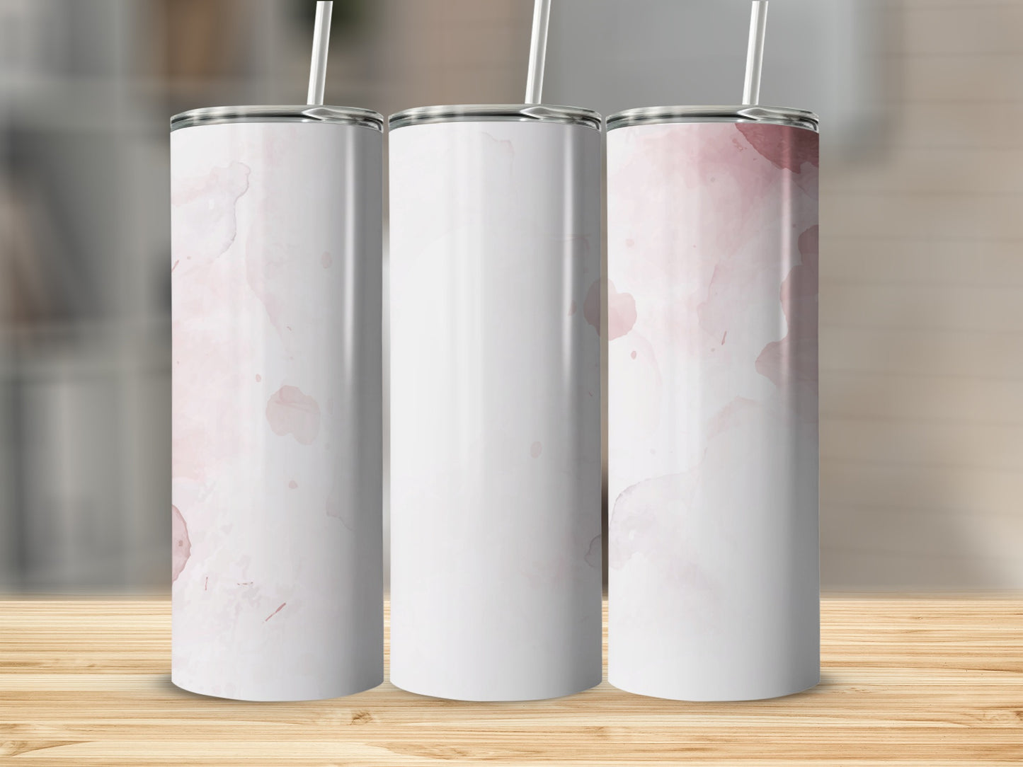 Three white tumblers with watercolor pink splotches and straws.