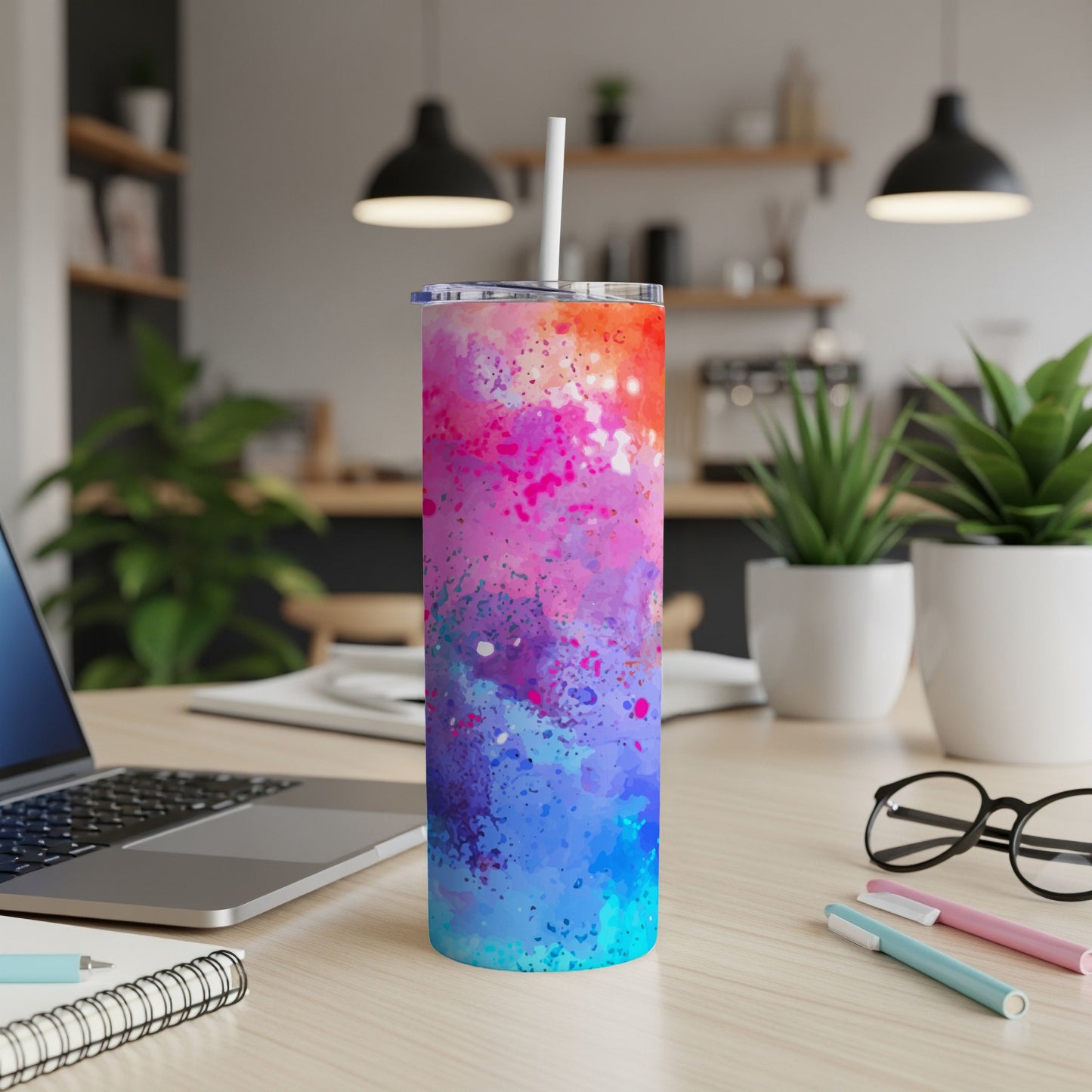 Tall tumbler with colorful ink splash design and white straw.