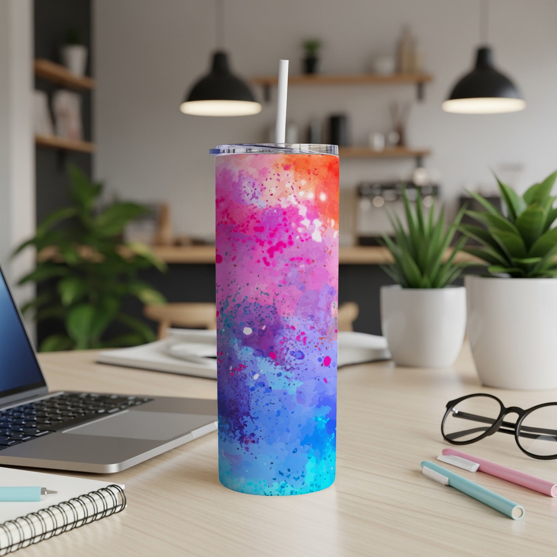 Tall tumbler with colorful ink splash design and white straw.