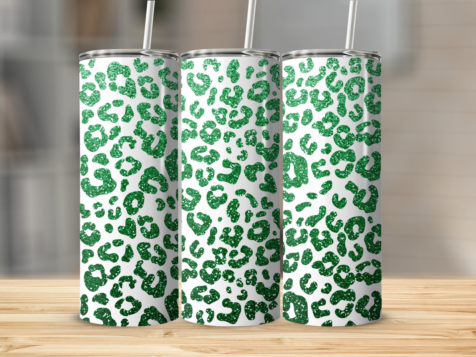 Three green glitter leopard print tumblers with white straws.