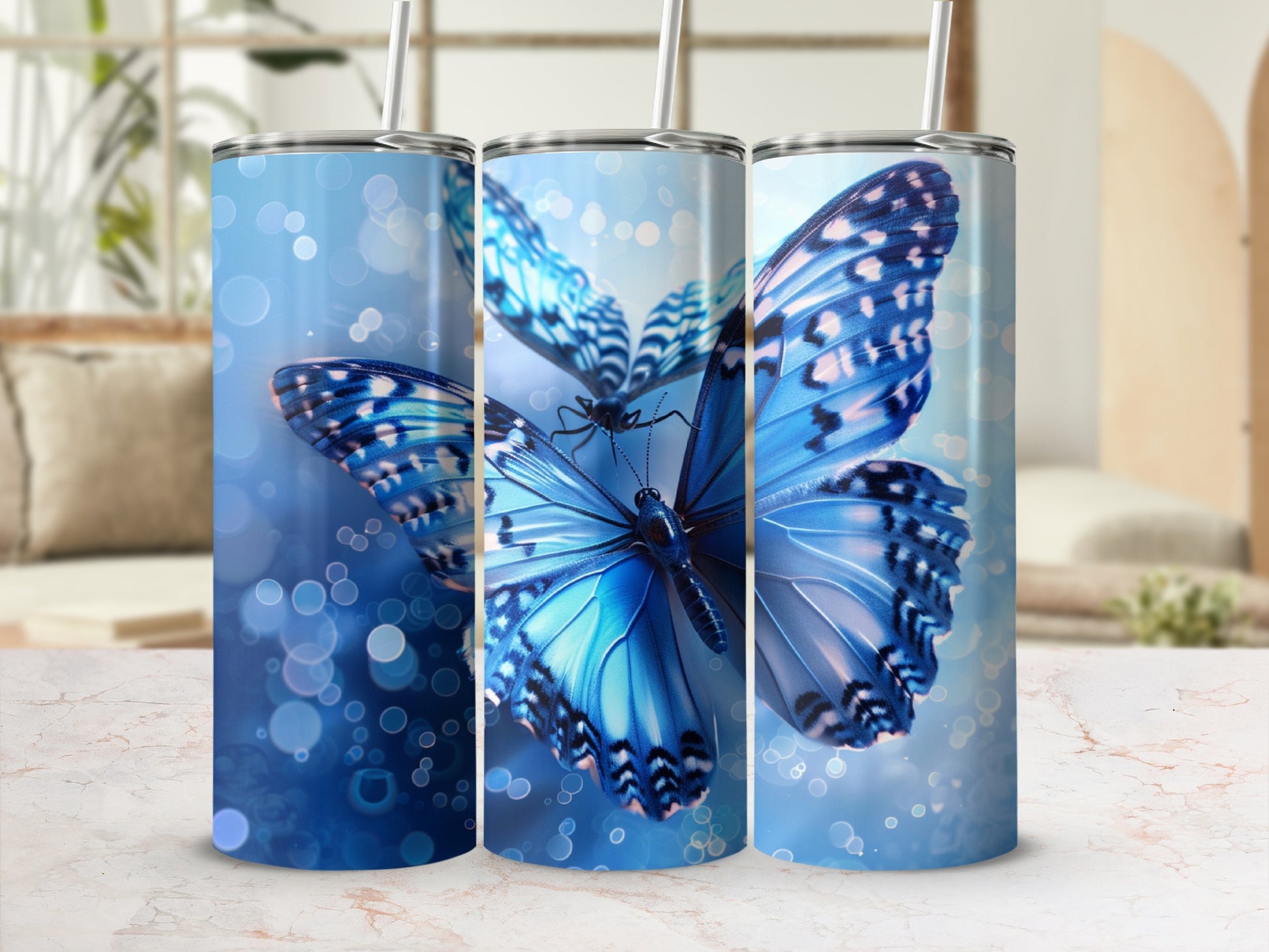 Three tumblers with vibrant blue butterflies and bokeh effect.