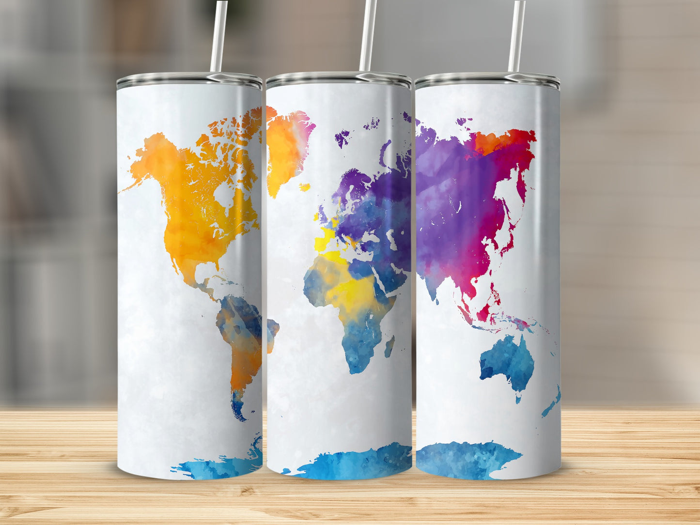 Three white tumblers with colorful watercolor world maps, each with a straw.