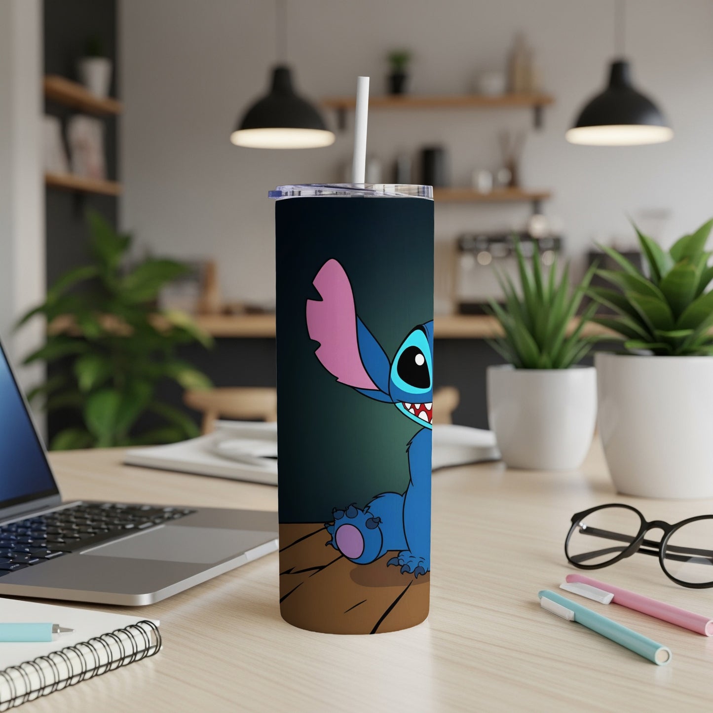 Blue Stitch character on a tumbler with a straw, on a desk.