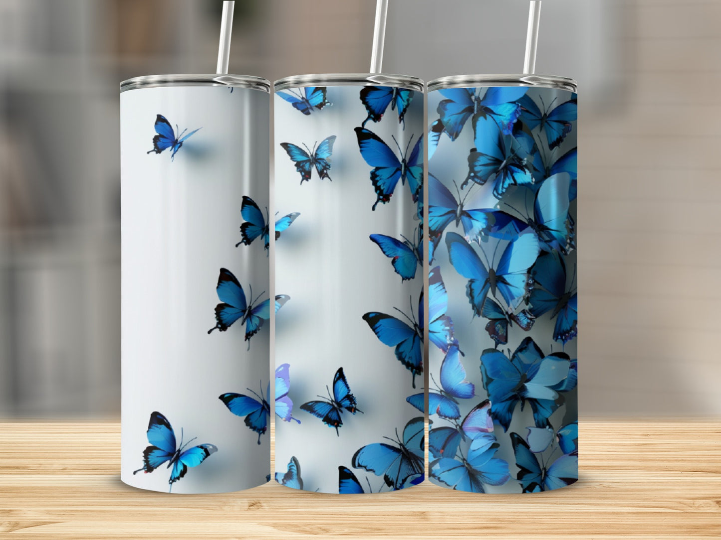 Three tumblers with blue butterflies on a light background.
