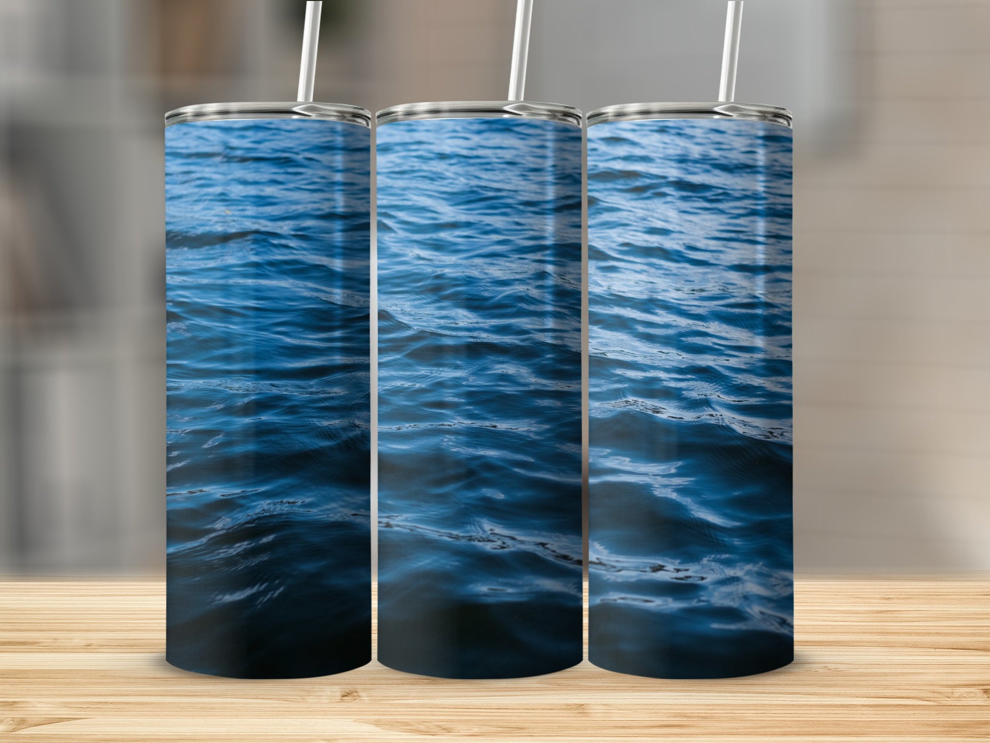 Three tumblers with a deep blue water pattern and white straws.