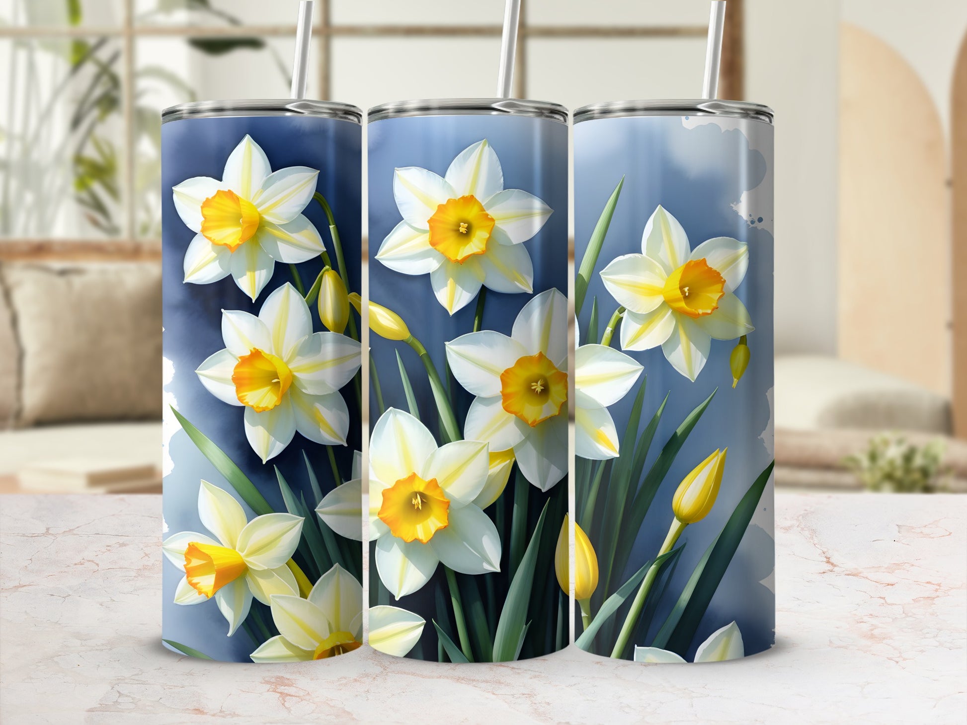 Three tumblers featuring white and yellow daffodils against a blue watercolor background.