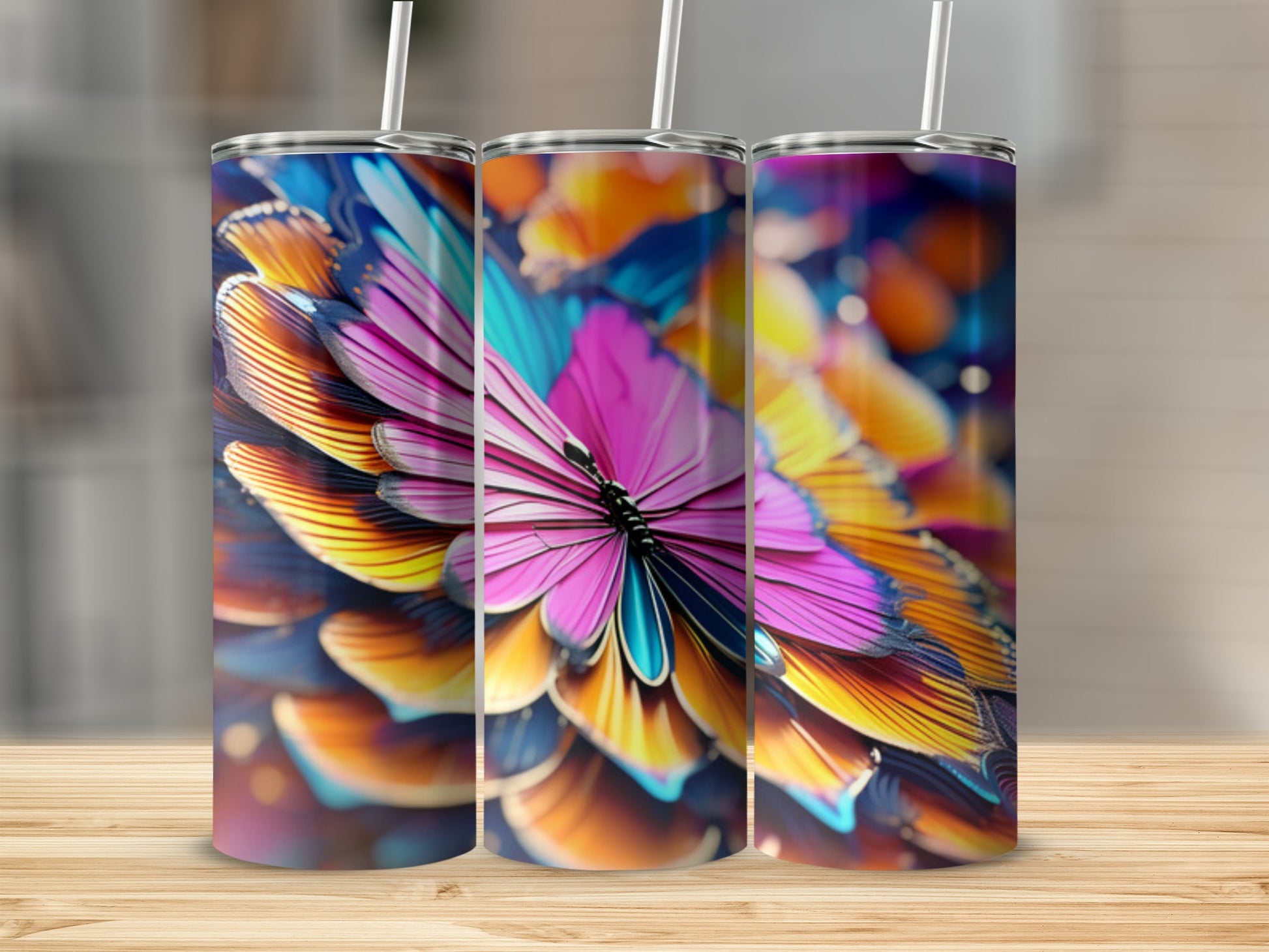 Three tumblers with vibrant butterfly wing designs on a wooden surface.