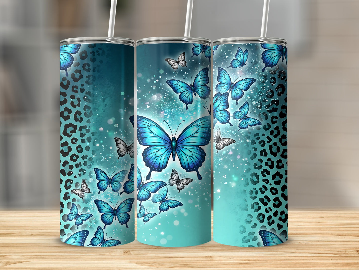 Three blue butterfly tumblers with leopard print and glitter accents.