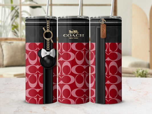 Coach pattern tumbler with faux leather trim, zipper detail, and charms.