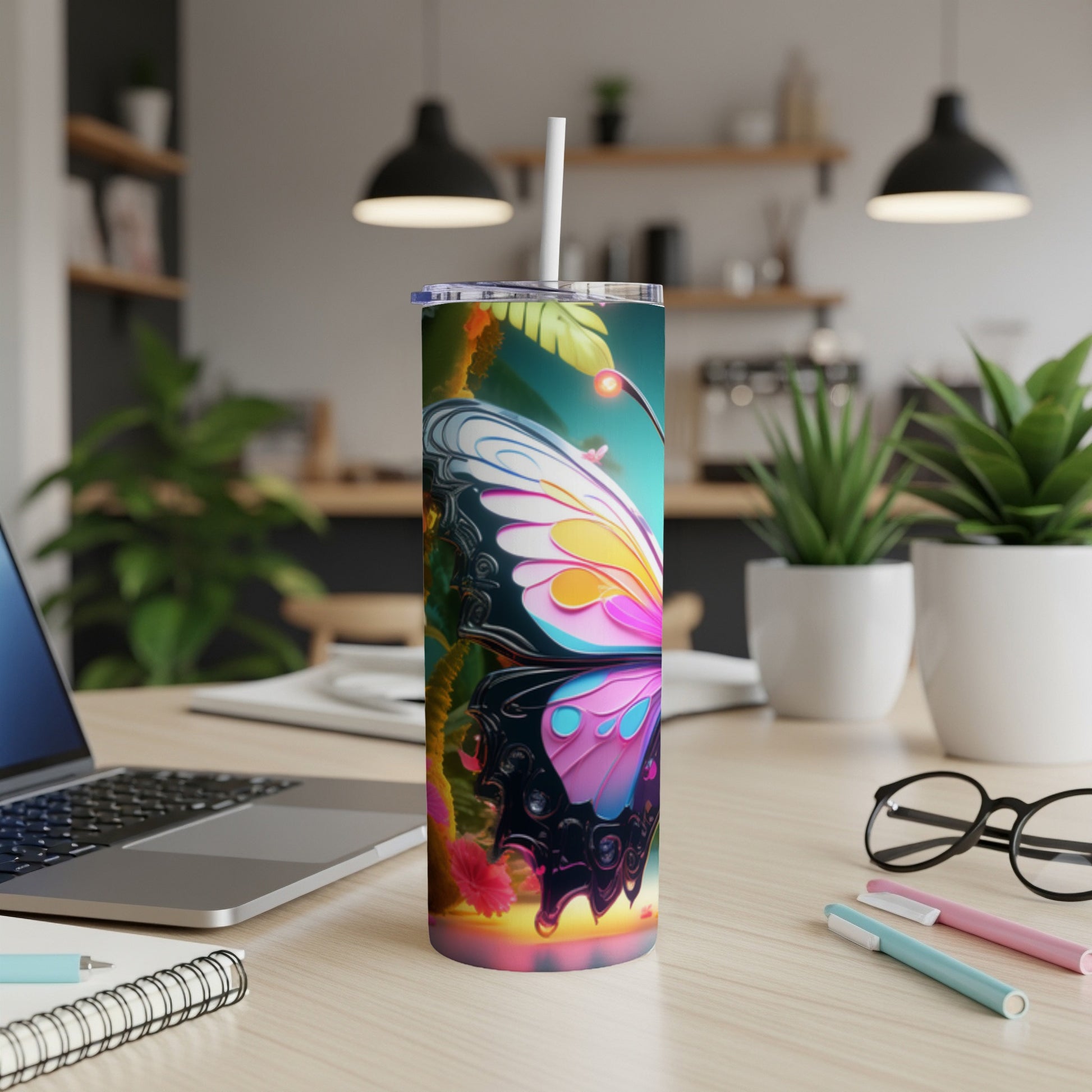 Butterfly design tumbler with straw on a desk.