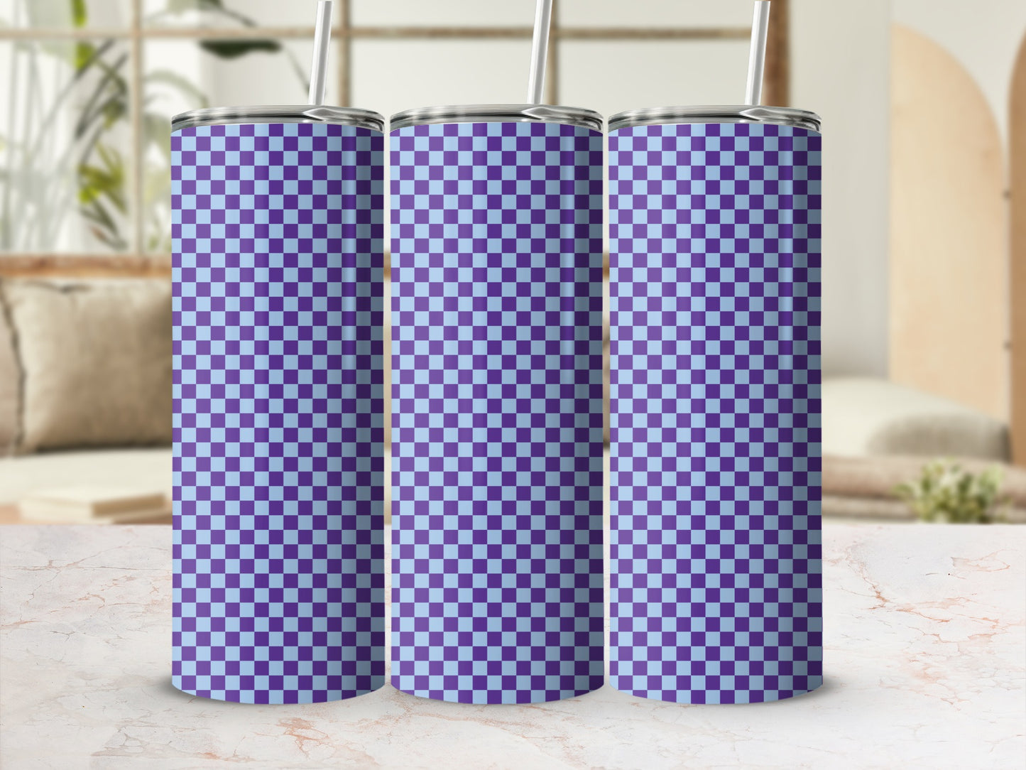 Three purple and light blue checkered tumblers with straws stand on a counter.