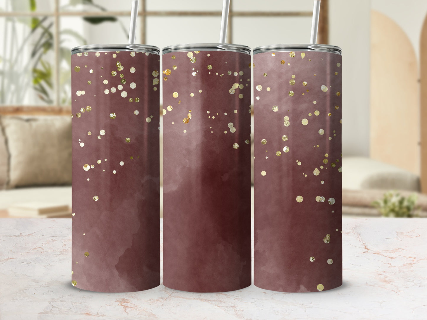 Three dark pink tumblers with gold glitter accents on a marble surface.