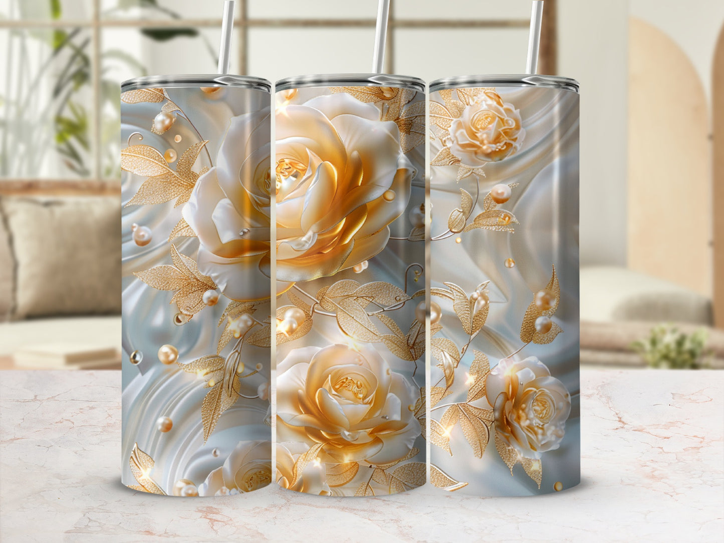 Three tumblers adorned with detailed golden roses, pearls, and leaves on a marble surface.