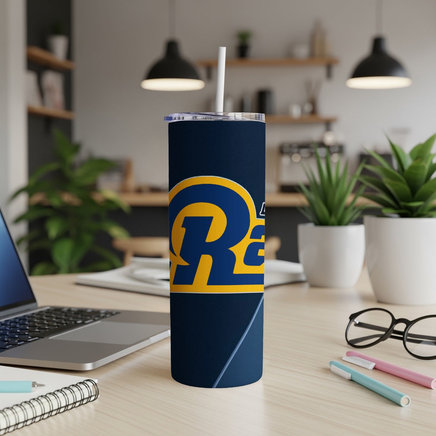 Los Angeles Rams tumbler with logo, straw, and lid on a desk.