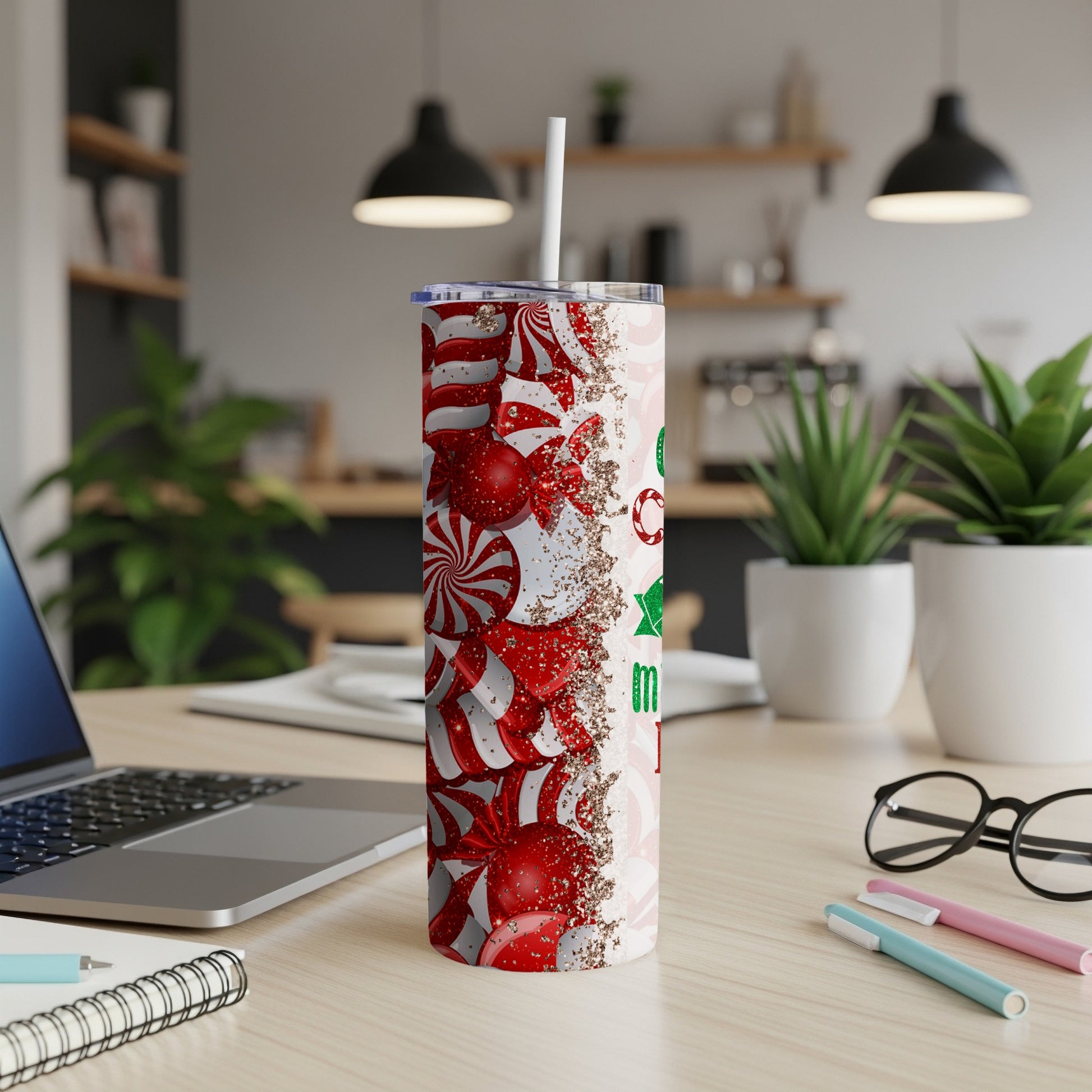 Christmas candy cane and ornament pattern tumbler with straw on desk.