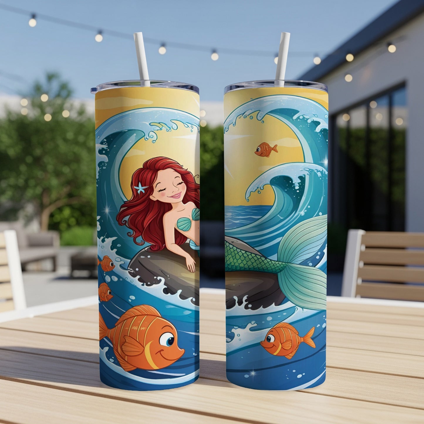 Two mermaid tumblers with a cartoon mermaid and fish on a beach scene.